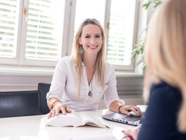 Eine Mitarbeiterin sieht freundlich in die Kamera.