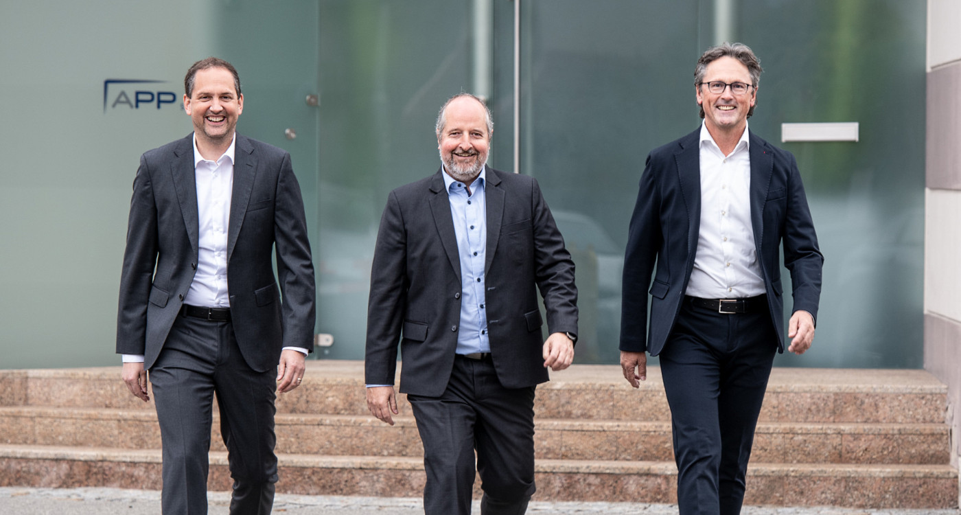 Drei Geschäftsführer vor dem Haupteingang der APP in Klagenfurt