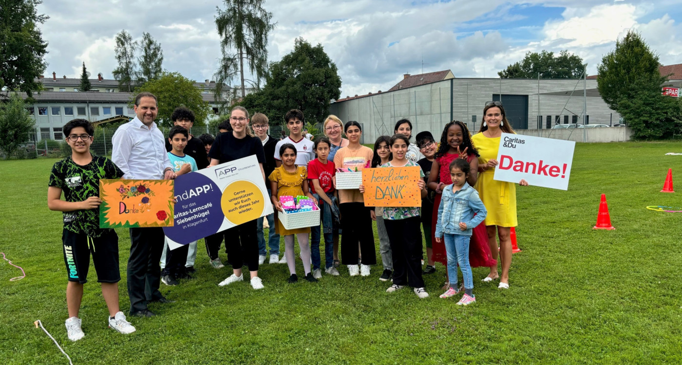 Kinder des Caritas Lerncafé Siebenhügel mit den Geschenken und Plakaten